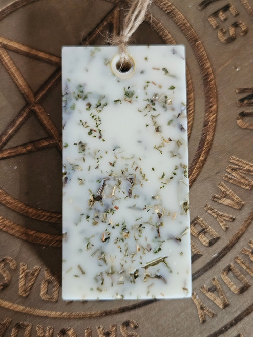 Rectangular scented pendant with natural ingredients on a textured surface