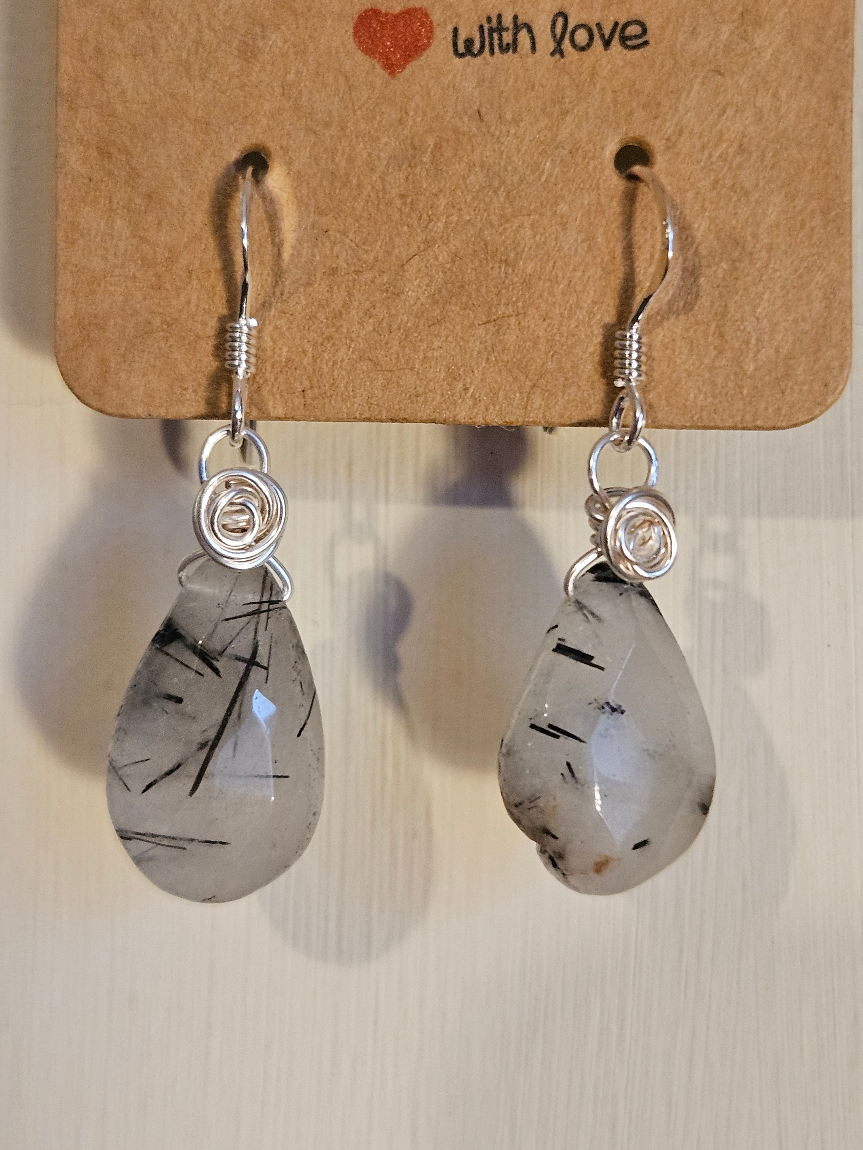 Pair of earrings with a textured stone design on a cardboard card with 'with love' text.