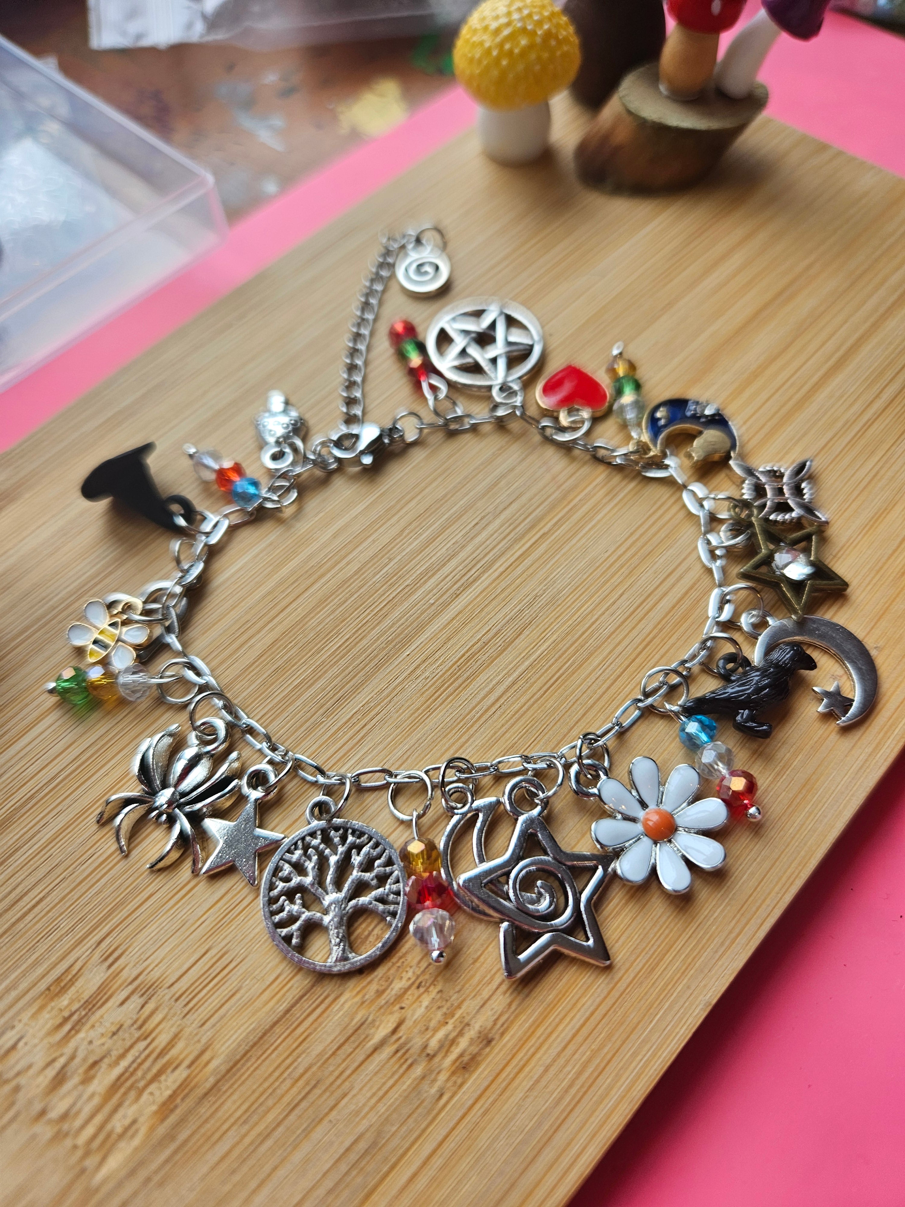 Silver charm bracelet with various charms on a wooden surface