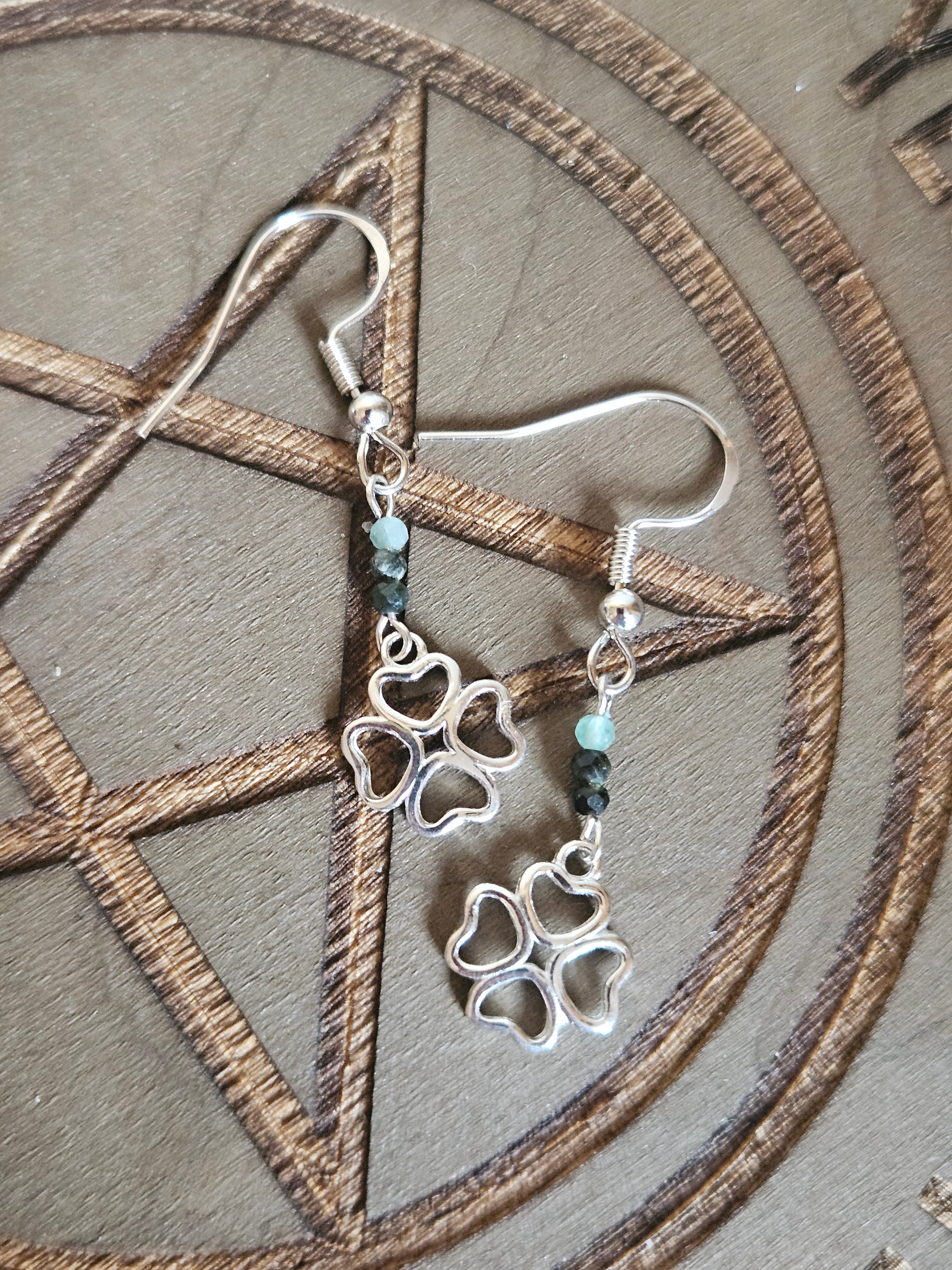 Silver 4 leaf clover earrings on a pentagram design background