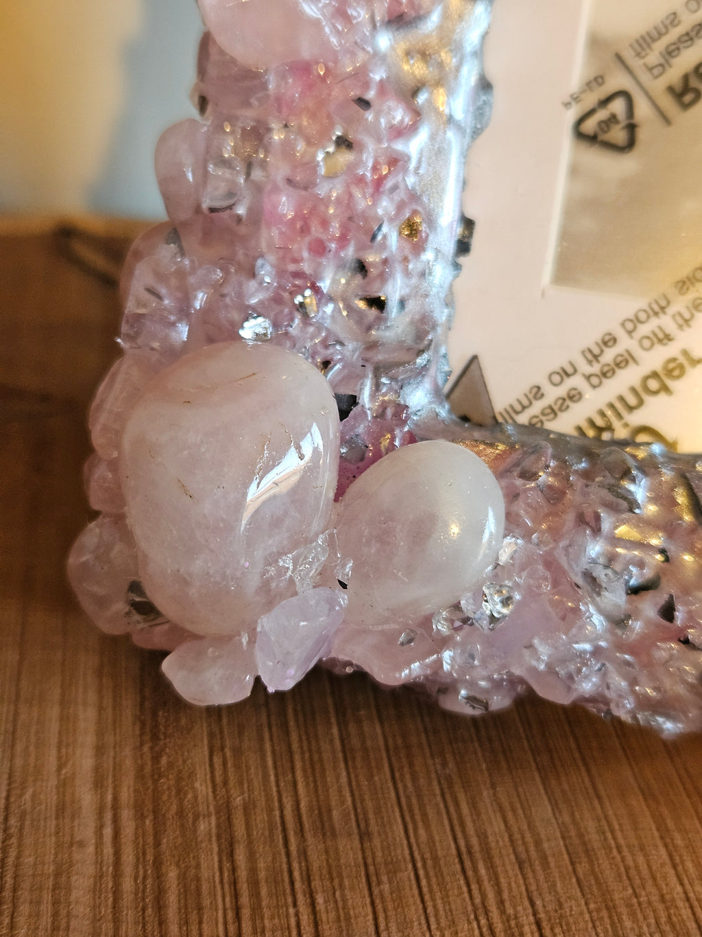 Close-up of a pink crystal photo frame on a wooden surface