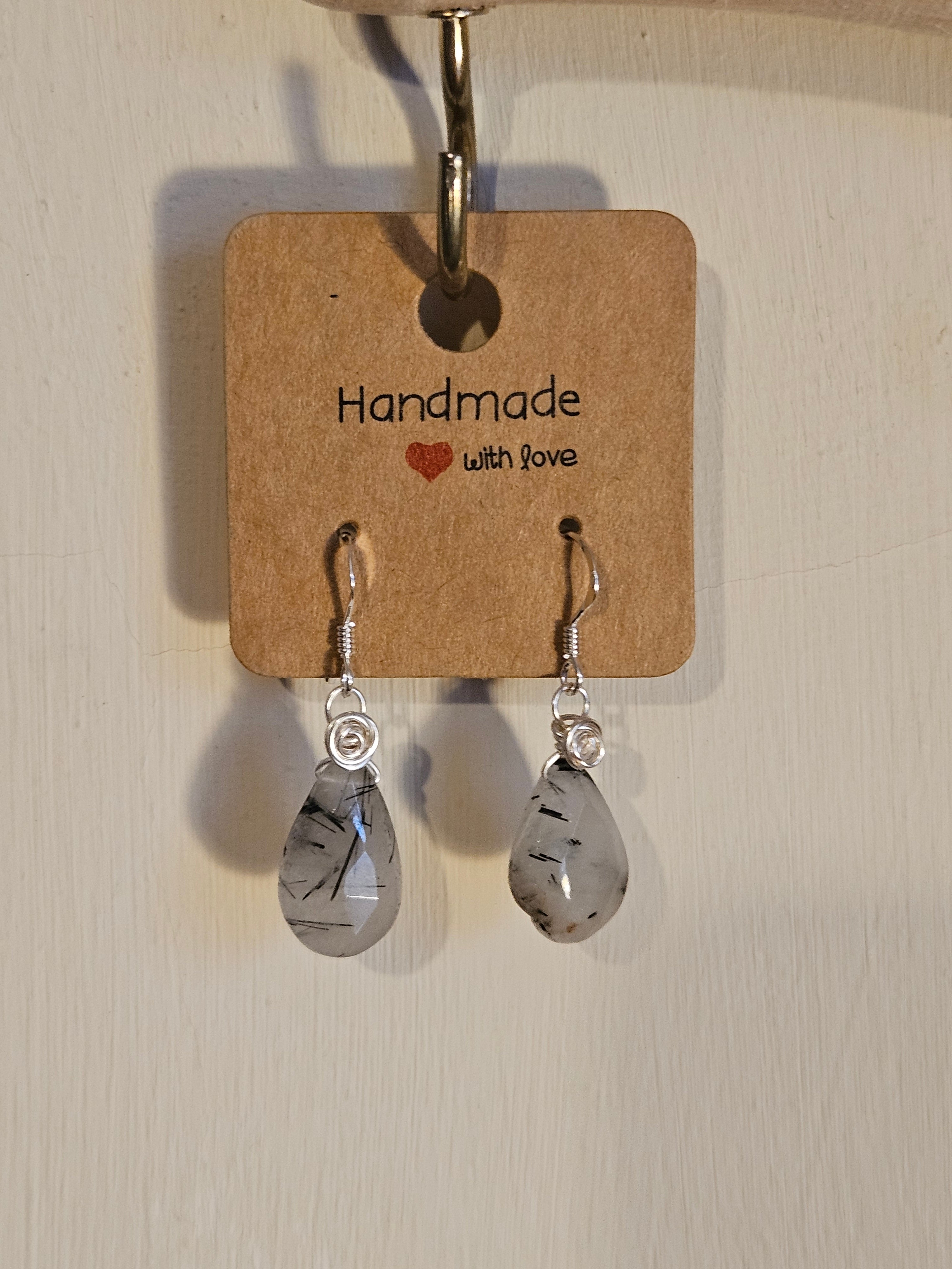 Pair of earrings on a 'Handmade with Love' card against a light background