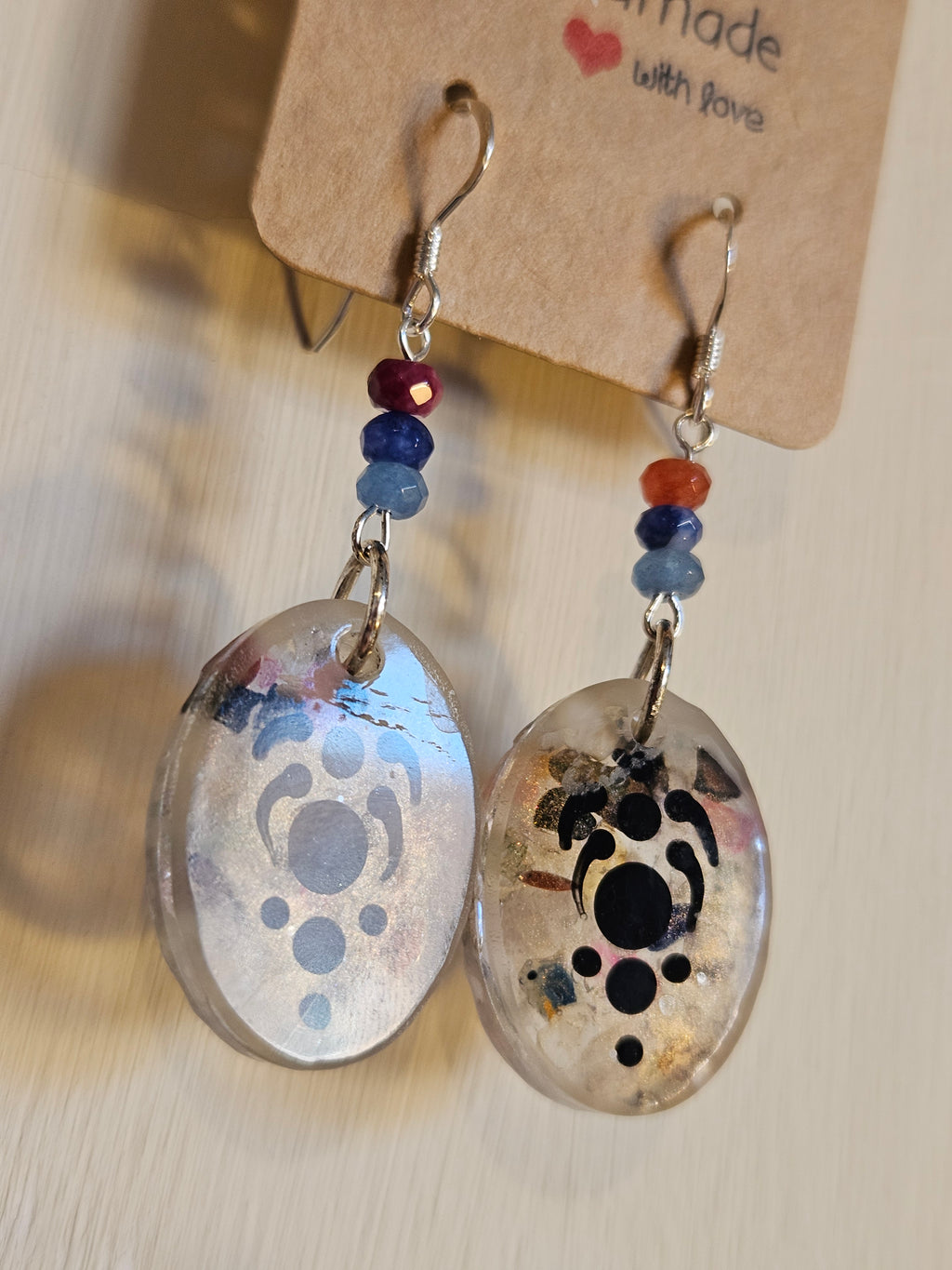 Pair of earrings with abstract designs on a beige background