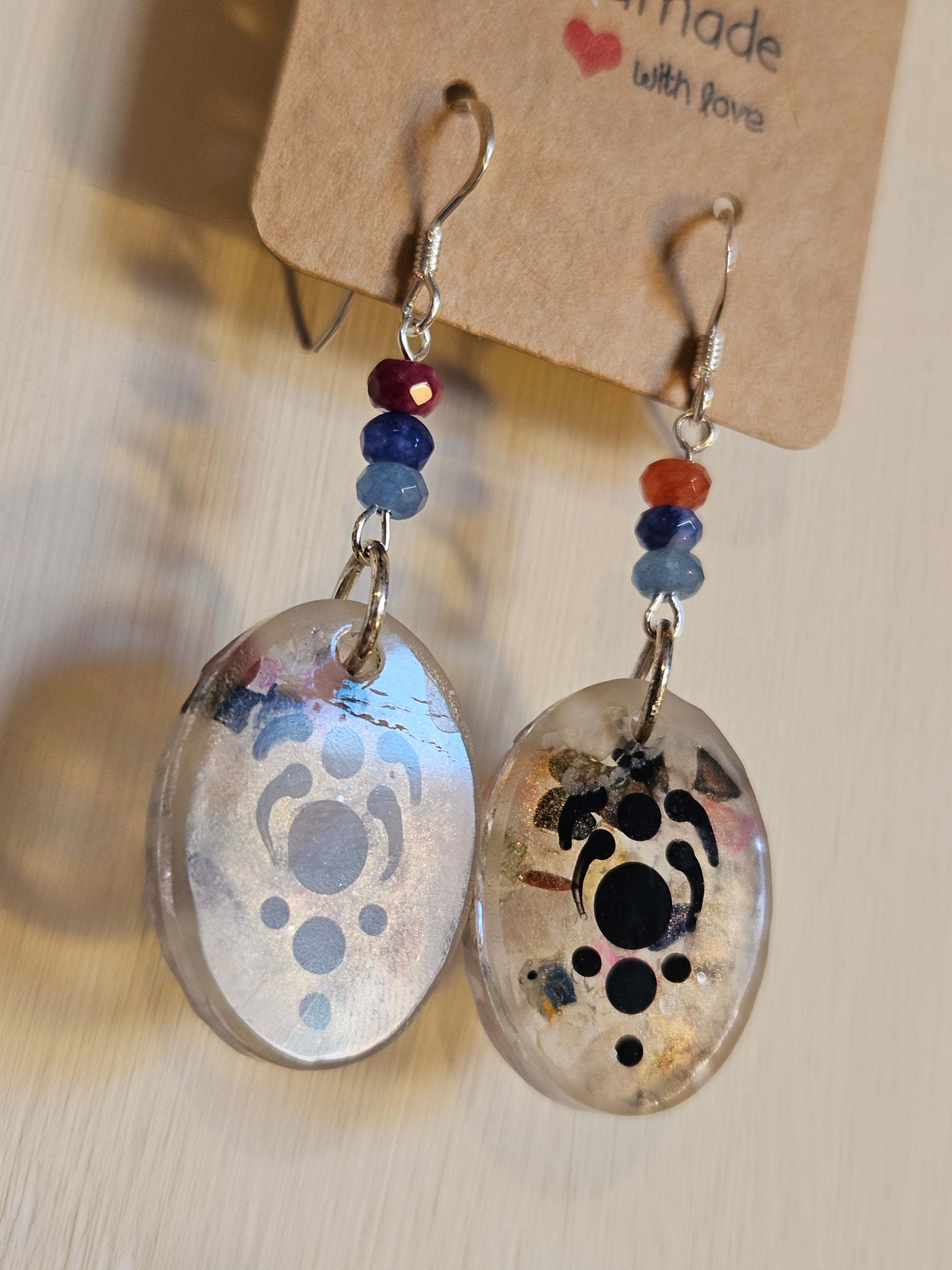 Pair of earrings with abstract designs on a beige background