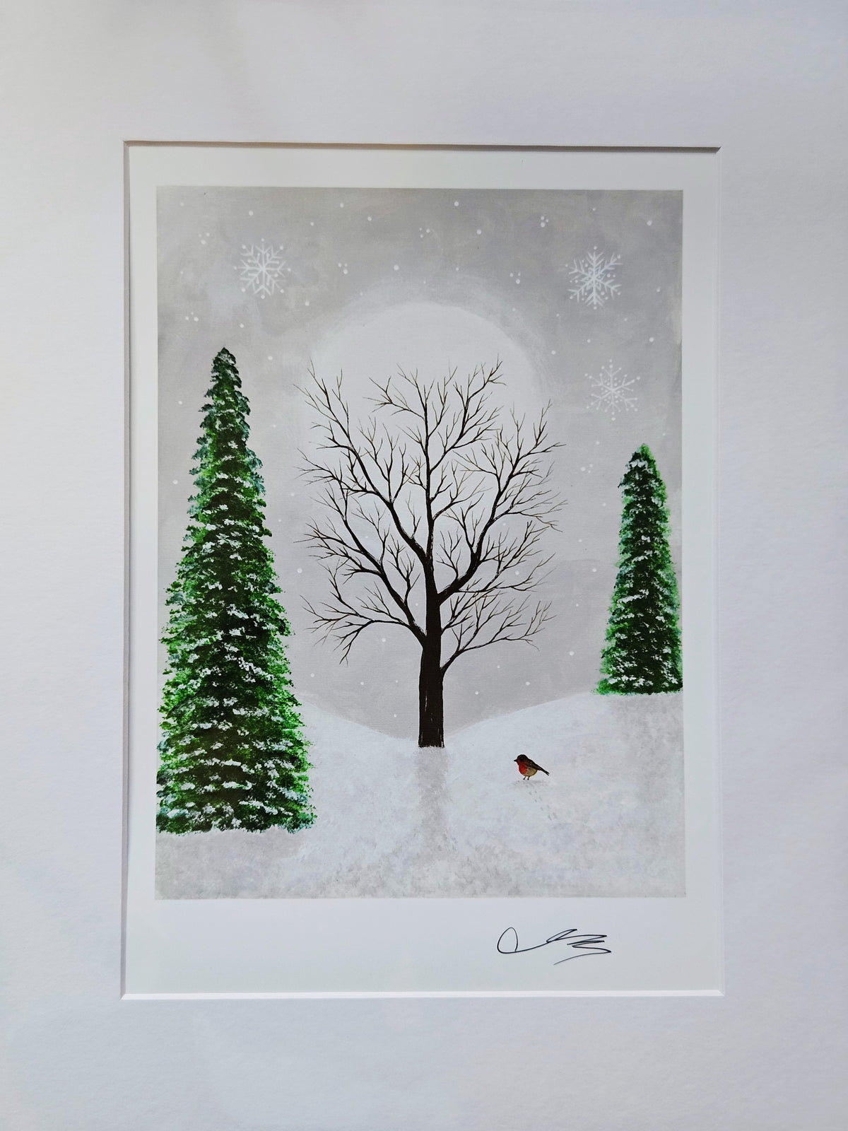 A signed art print depicting a winter landscape with a central bare tree, two snow-covered evergreen trees, a small robin bird, and a pale moonlit sky with snowflakes.