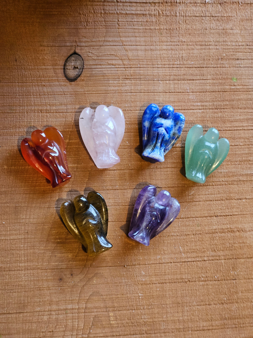 Six mini angels in various gemstones on a wooden board