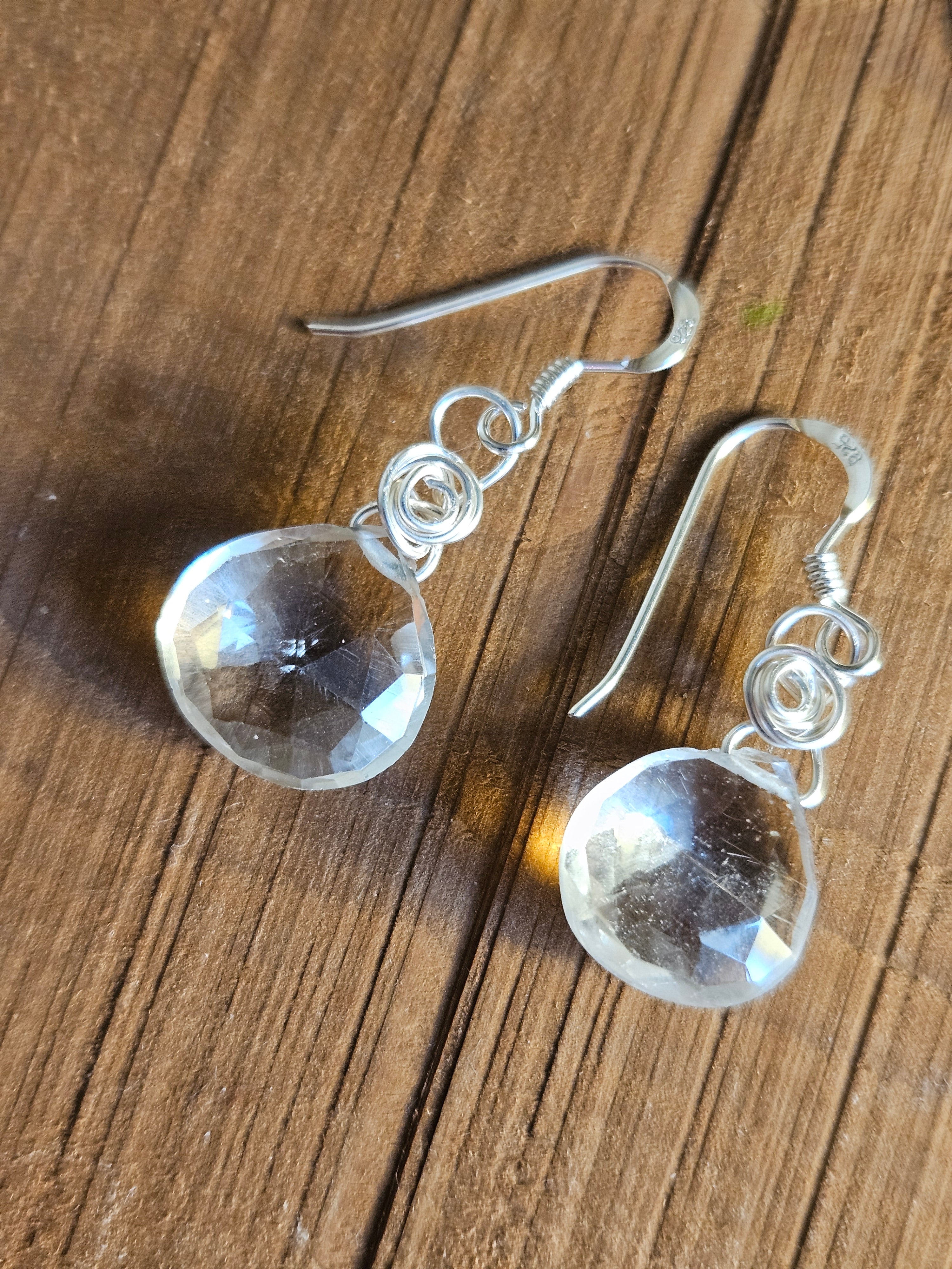 Clear crystal earrings on a wooden surface